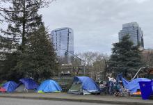 People camp in tents next to the Interstate 405 freeway, March 31 in Portland, Oregon. (AP photo/Eric Risberg)