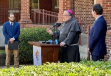 Bishop John Stowe of Lexington, Kentucky, center, speaks at press conference. With him are Bishop John Stowe of Lexington, Kentucky, announces a net-zero initiative.  With him are Adam Edelen (right), founder and CEO of Edelen Renewables, and Joshua Van Cleef (left).