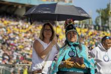 Two women listen as Pope Francis celebrates Mass at Commonwealth Stadium, July 26 in Edmonton, Alberta. Francis traveled to Canada to apologize to Indigenous peoples for the abuses committed by Catholic missionaries in the country’s residential schools. 