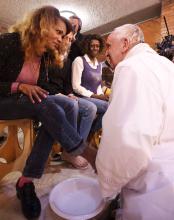 Francis washing the feet of a female inmate for Holy Thursday