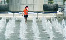 Child playing in a fountain with a sprinkler 