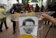 An image of Florida Gov. Ron DeSantis is overlaid with the words "Don't attack our democracy" at a rally to denounce the governor's immigration policies Sept. 20 in Doral, Florida. (AP/Rebecca Blackwell)