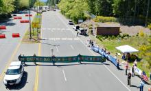 Protesters hold a banner while blocking the Main Gate entrance to Naval Base Kitsap-Bangor May 12 as part of a protest against the Trident submarine base in honor of Mother's Day for Peace. (Ground Zero Center for Nonviolent Action/Glen Milner)