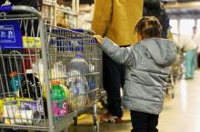 A young girl helps guide a shopping cart Nov. 15 through the food pantry operated by the Indianapolis Council of the Society of St. Vincent de Paul. The Catholic-run pantry serves about 3,000 local families each week. (CNS/Katie Rutter) 