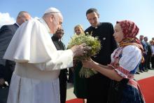 Pope Francis accepts flowers as he is welcomed by Slovak President Zuzana Caputová at the international airport in Bratislava, Slovakia, Sept. 12, 2021.