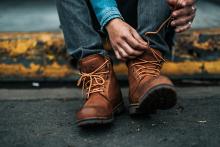 Putting on boots (Unsplash/Nathan Dumlao)