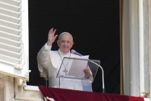 Pope Francis waves to the crowd as he arrives to recite the Angelus noon prayer from the window of his studio overlooking St.Peter's Square