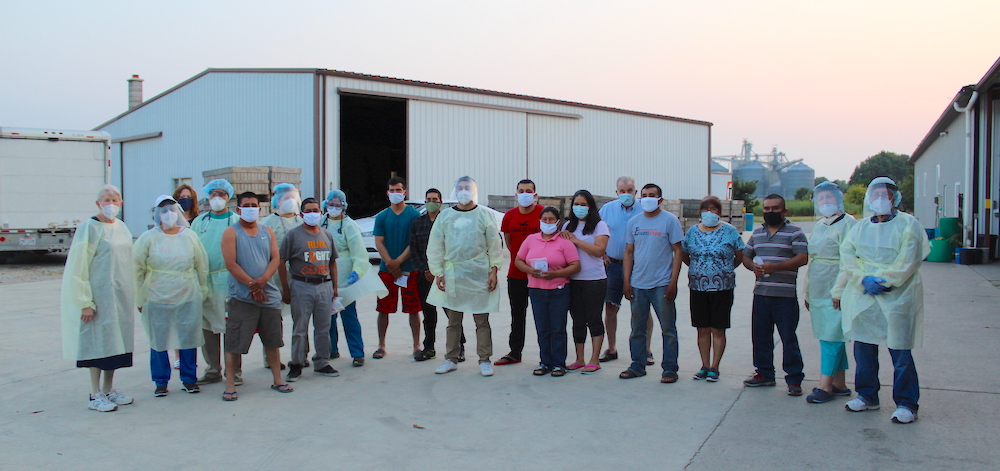 Migrant farm workers and medical team pose at Eshleman Farm in Clyde, Ohio, Aug. 26 (Kate Oatis)