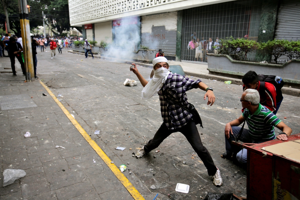 A demonstrator throws a tear gas canister back to riot police April 30 in Tegucigalpa, Honduras, during a protest against government plans to privatize health care and education. (CNS/Reuters/Jorge Cabrera) A demonstrator throws a tear gas canister back to riot police April 30 in Tegucigalpa, Honduras, during a protest against government plans to privatize health care and education. (CNS/Reuters/Jorge Cabrera)