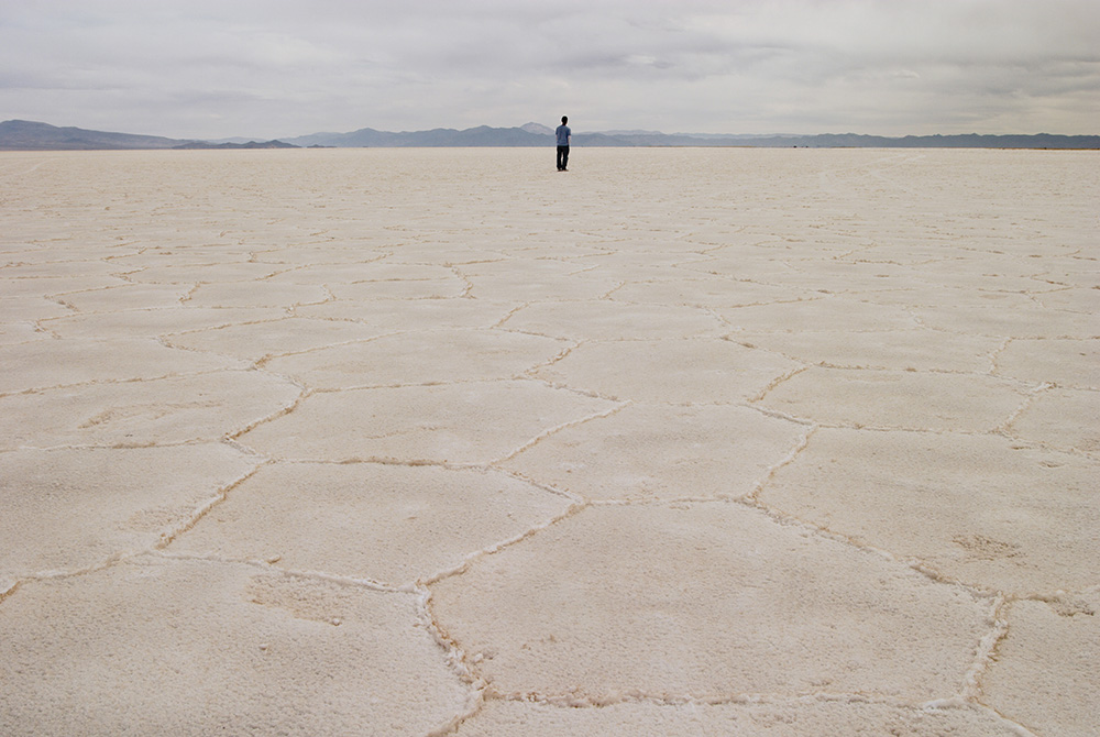 A person stands on the salt flat Salar de Arizaro, in Salta province, Argentina. In Salta and Jujuy provinces, Indigenous communities, whose livelihood depends on the extraction of salt from great deposits, oppose lithium mining, which directly impacts th A person stands on the salt flat Salar de Arizaro, in Salta province, Argentina. In Salta and Jujuy provinces, Indigenous communities, whose livelihood depends on the extraction of salt from great deposits, oppose lithium mining, which directly impacts th