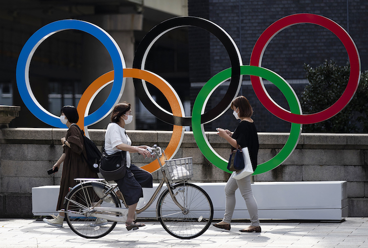 People walk by the Olympic rings installed by the Nippon Bashi bridge in Tokyo on Thursday, July 15, 2021. (AP Photo/Hiro Komae)