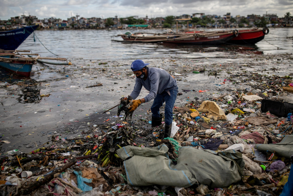 Argie Aguirre, a member of the River Warriors, gathers trash from the polluted Pasig River in Manila, Philippines, June 22, 2021. (CNS/Reuters/Eloisa Lopez) 