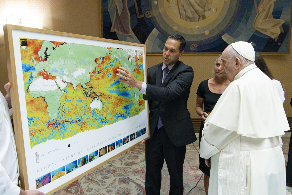 Ecologist Gregory Asner of Arizona State University shows Pope Francis a map from a new atlas of the world's coral reefs in August at the Vatican. (Courtesy of Vatican Media)