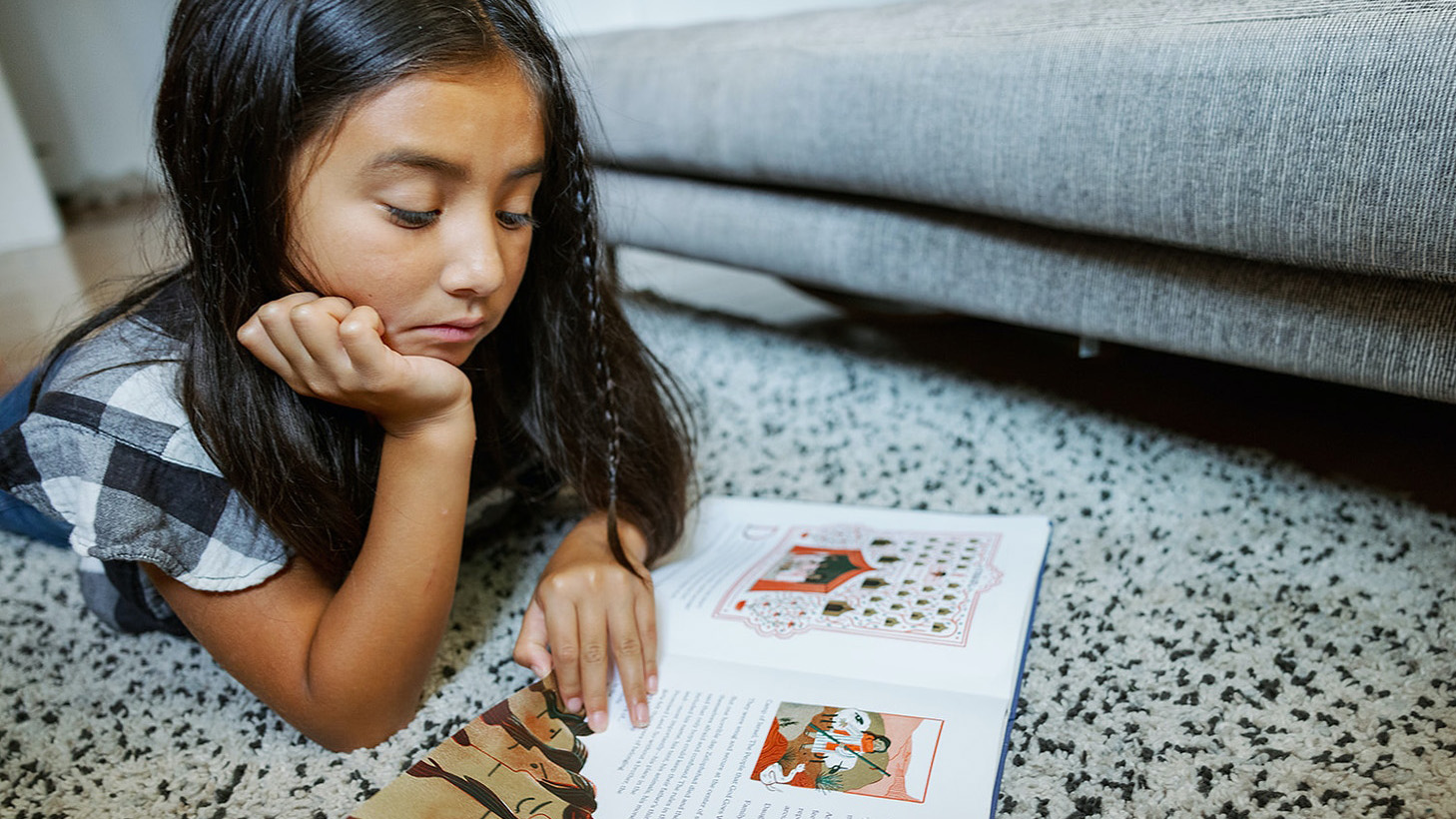 A child reads a sample of "The Book of Belonging." (Photo by Daniel Ebersole)