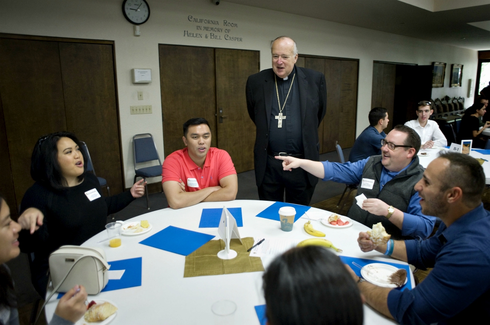 Bishop Robert McElroy joins a table discussing one of the 31 proposals during the Young Adult Synod in San Diego. (David Maung)